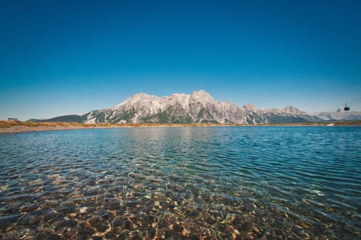 Asitz mountain in the background of the pure and calm lake, Austria
