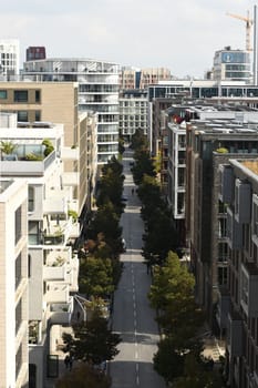 Vertical aerial view of Am Kaiserkai avenue buildings and trees on a sunny day in Hamburg, Germany