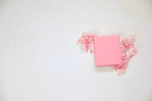 Open and closed pink gift box place for product on bright background with flowers .Flat lay, top view, mock-up gift,present Mothers Day,Valentines Day, Birthday concept copy space