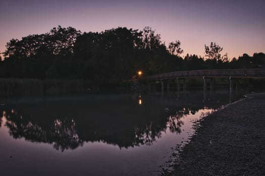 Mangfallsteg bridge with the reflection in river at dusk near Gmund am Tegernsee, Bavaria, Germany