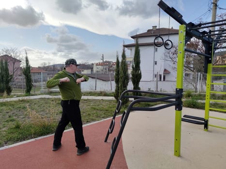 middle-aged man exercising on an outdoor sports ground.