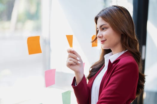 Beautiful young teen asian businesswoman using note pad thinking with planning working on financial document, tax, exchange, accounting and Financial advisor.