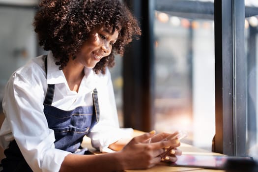 Startup successful small Beautiful American African owner sme with tablet in coffee shop restaurant, hands up in winner is gesture, Happy to be successful celebrating achievement success.