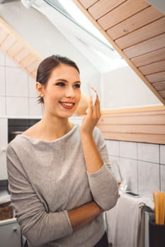 Beautiful young woman cleaning her face, removing make up with a cotton pad and micellar water. Skin care and beauty. Young beautiful woman cleaning her face. High quality photo