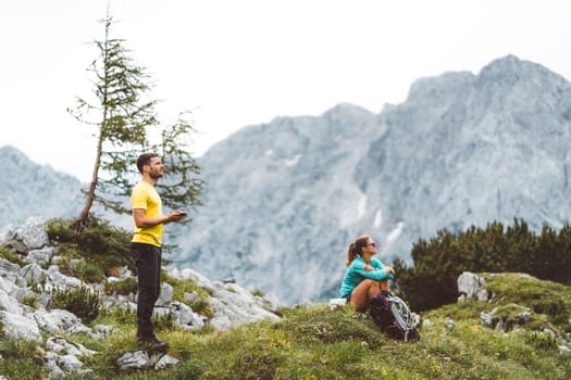 Couple of Young Happy Travelers Hiking with Backpacks on the Beautiful trail in European Alps early in the morning. Travel and Adventure Concept. High quality photo