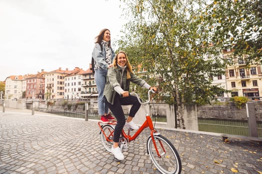 Two young caucasian women having fun on city street outdoors - Best friends enjoying a holiday day out together - Happy lifestyle, youth and young females concept. High quality photo