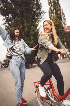 Two young caucasian women having fun on city street outdoors - Best friends enjoying a holiday day out together - Happy lifestyle, youth and young females concept. High quality photo