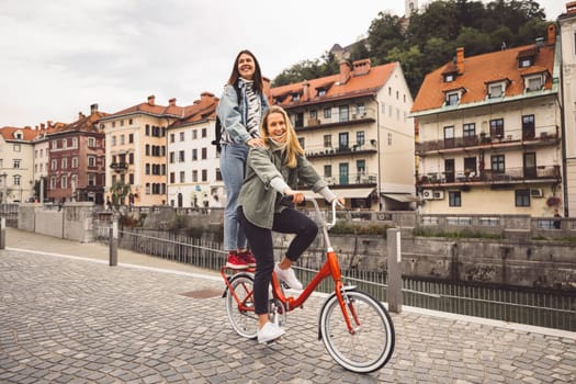 Two young caucasian women having fun on city street outdoors - Best friends enjoying a holiday day out together - Happy lifestyle, youth and young females concept. High quality photo