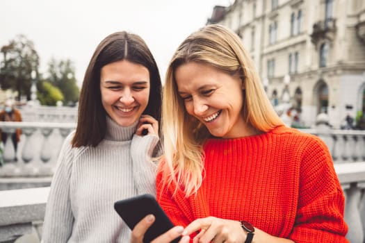 Two young caucasian women having fun on city street outdoors - Best friends enjoying a holiday day out together - Happy lifestyle, youth and young females concept. High quality photo