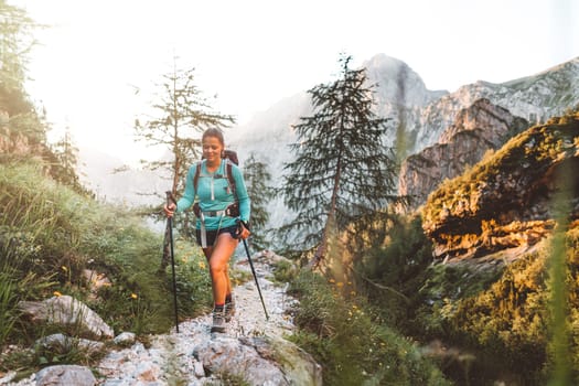 Caucasian woman hiking with Backpack on the Beautiful trail in European Alps early in the morning. Travel and Adventure Concept. High quality photo