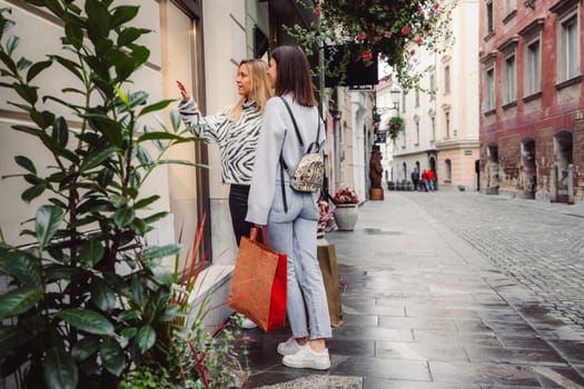 Two young caucasian women having fun on city street outdoors - Best friends enjoying a holiday day out together - Happy lifestyle, youth and young females concept. High quality photo