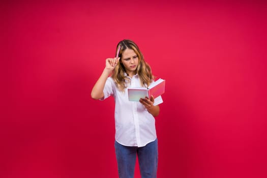 Child making notes. Kids dreams.Isolated on a red background. Education, Kid back to school.