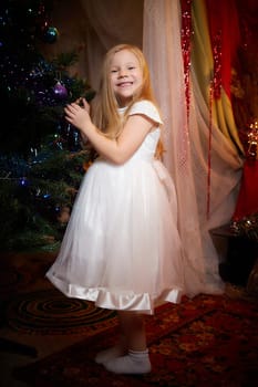 Beautiful girl in a white dress on the background of a Christmas tree. New year and christmas concept