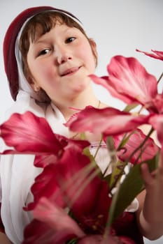 Portrait of Little girl in a stylized Tatar national costume with flowers on a white background in the studio. Photo shoot of funny young teenager who is not a professional model