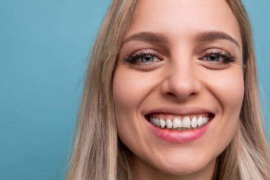 portrait of a woman with a snow-white Hollywood smile and on a blue background.