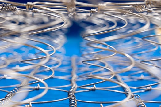 Abstract background The internal structure of a spring mattress. close-up of an old spring mattress on a blue background. Spring block. Sofa and bed. defocusing