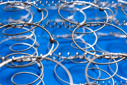 Abstract background The internal structure of a spring mattress. close-up of an old spring mattress on a blue background. Spring block. Sofa and bed. defocusing