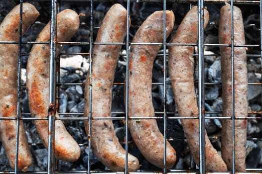 Grilling sausages on the steel grid