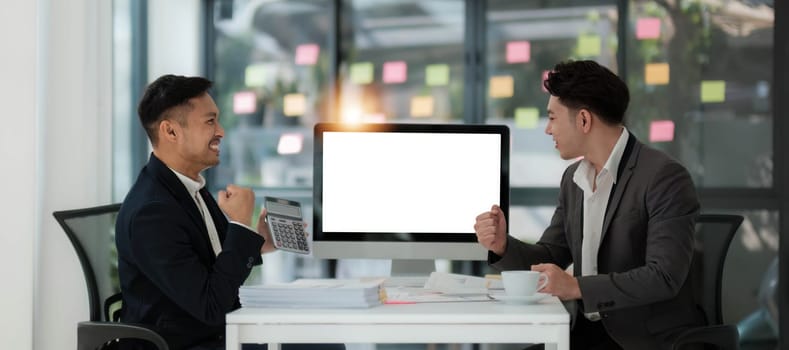 Two business people talk project strategy at office meeting room. Businessman discuss project planning with colleague at modern workplace while having conversation and advice on financial data report