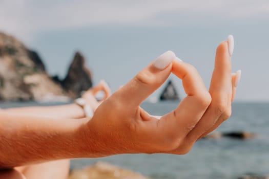 Woman sea yoga. Back view of free calm happy satisfied woman with long hair standing on top rock with yoga position against of sky by the sea. Healthy lifestyle outdoors in nature, fitness concept.