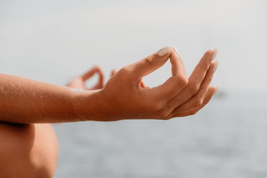 Woman sea yoga. Back view of free calm happy satisfied woman with long hair standing on top rock with yoga position against of sky by the sea. Healthy lifestyle outdoors in nature, fitness concept.