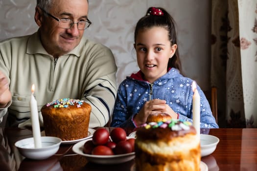 Family Decorating Easter Eggs On Table, grandfather and granddaughter