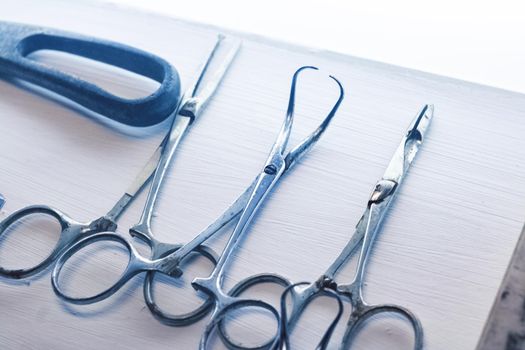 Old surgical metal medical devices on a wooden table close up