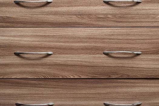 Wooden drawer shelves with metal handles close up