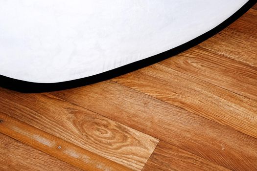 White board on wooden floor close up, copy space