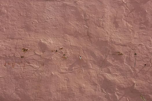 shabby dry pink plaster under direct sunlight texture and full frame background