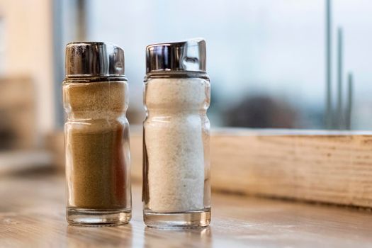 Salt shaker and pepper shaker on a wooden table