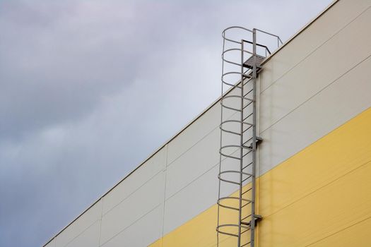 Ladder to the roof of a tall building on a dark sky background, copy space