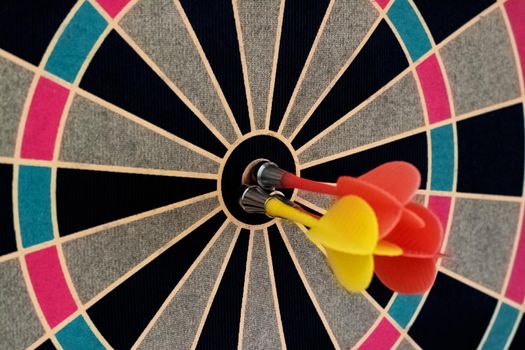 Darts board with darts in the center close up, copy space