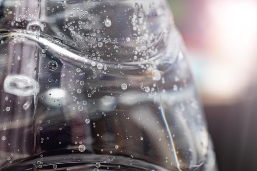 Bubbles in a water bottle in sunlight close up