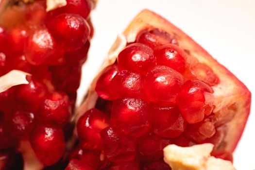 Sliced pomegranate with red grains close up, macro photo