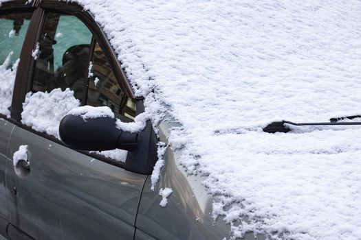 The first snow on a car windshield close up