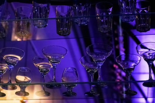 Glass goblets on a shelf in a bar lose up