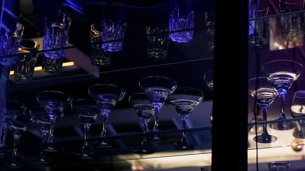 Glass goblets on a shelf in a bar lose up