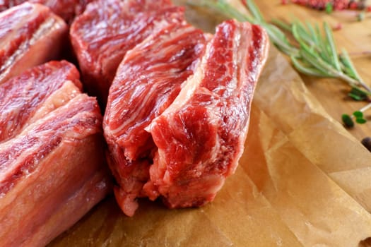 Raw cowboy steak on wooden background, prime rib eye on bone. Close up
