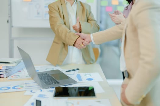 Asian entrepreneurs handshakes to congratulate the agreement between the two companies to enhance investment and financial strength. deal concept.