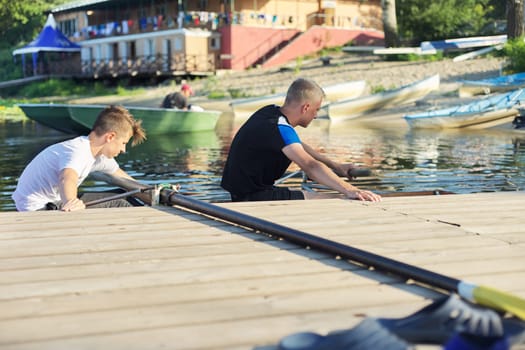 Team of two teenage boys kayaking on river. Active youth lifestyle, water sports, kayak, canoe