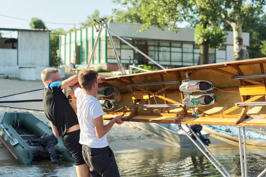 Team of two teenage boys kayaking on river. Active youth lifestyle, water sports, kayak, canoe