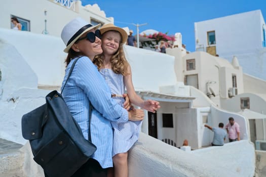 Summer mediterranean sea cruise holidays on Greek island Santorini, Oia village, mother and little daughter travel together