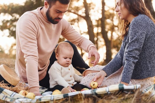 Haves picnic. Happy family of mother, family and little baby rests outdoors. Beautiful sunny autumn nature.