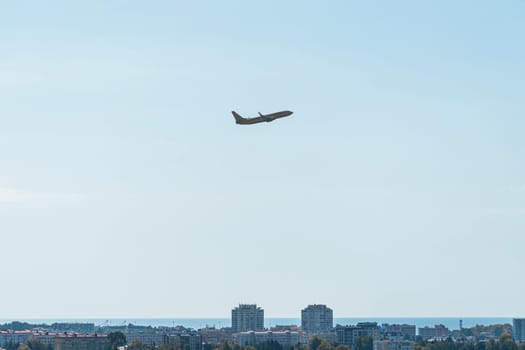 the plane is flying against a background of blue sky and sun. photo