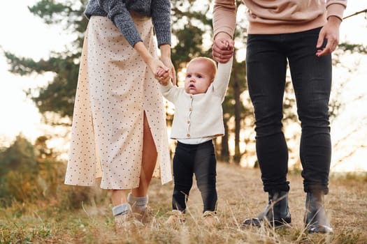 Unity of the people. Happy family of mother, family and little baby rests outdoors. Beautiful sunny autumn nature.