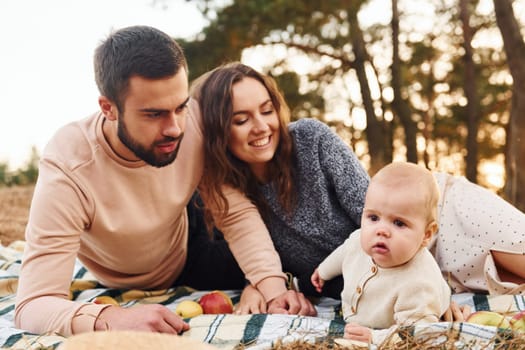 Haves picnic. Happy family of mother, family and little baby rests outdoors. Beautiful sunny autumn nature.