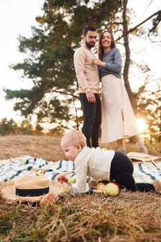 Haves picnic. Happy family of mother, family and little baby rests outdoors. Beautiful sunny autumn nature.