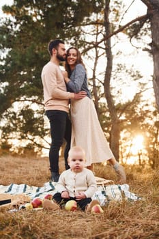 Haves picnic. Happy family of mother, family and little baby rests outdoors. Beautiful sunny autumn nature.