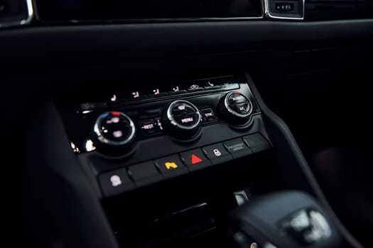 Knobs and buttons. Close up focused view of brand new modern black automobile.